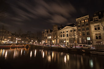 Night cityscape of Amsterdam canal with long exposure reflections