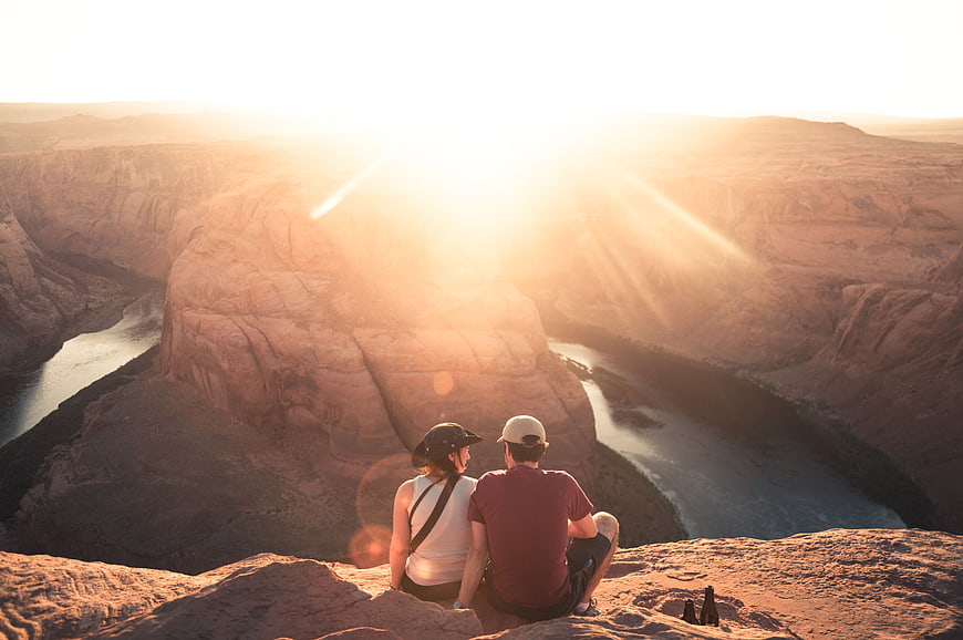 Couple watching sunset over Horseshoe Bend canyon