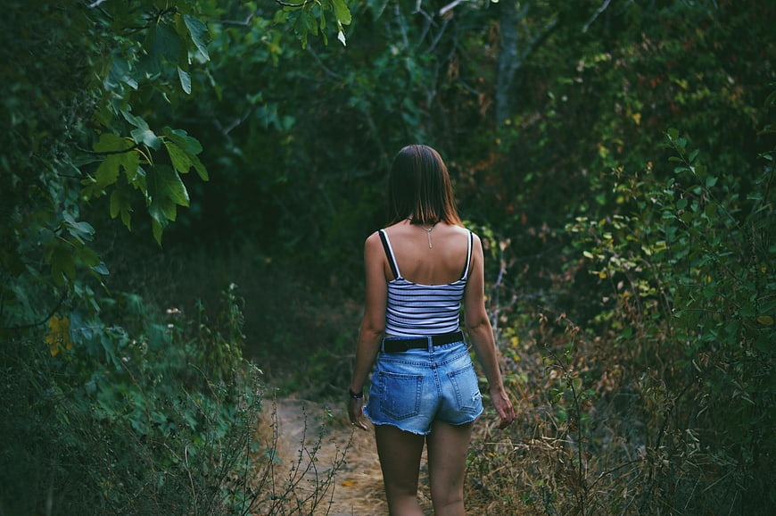 Woman Walking Away on Forest Path in Denim Shorts