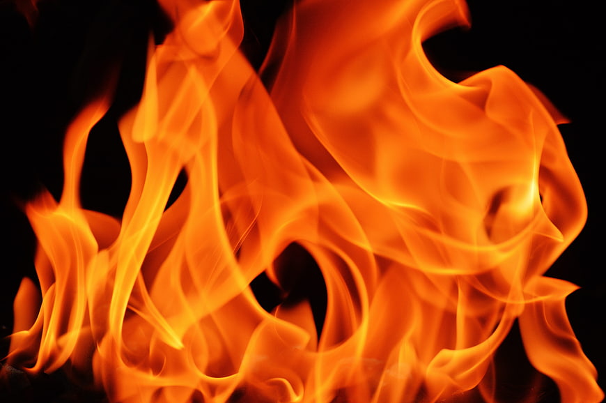 Close-up of vibrant orange flames against a black background