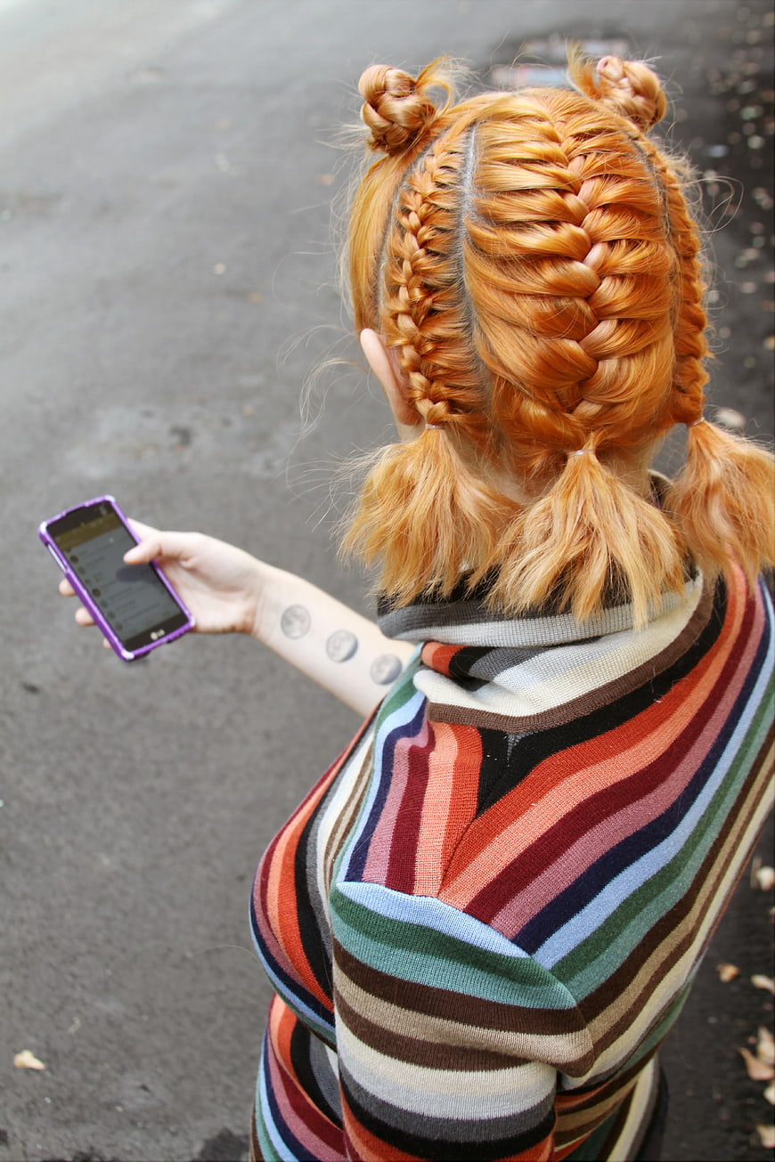 Woman with Braided Orange Hair Holding Smartphone