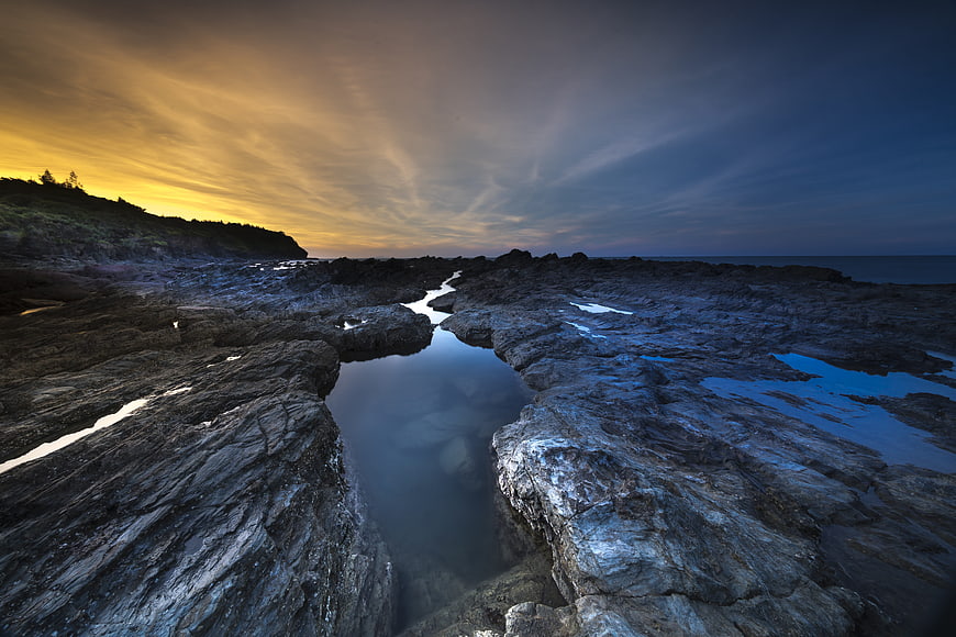 Dramatic Volcanic Rock Coastline at Sunrise with Turquoise Pools
