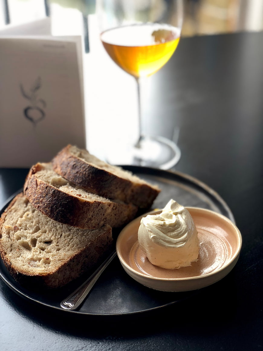 Sourdough bread slices with whipped butter and white wine