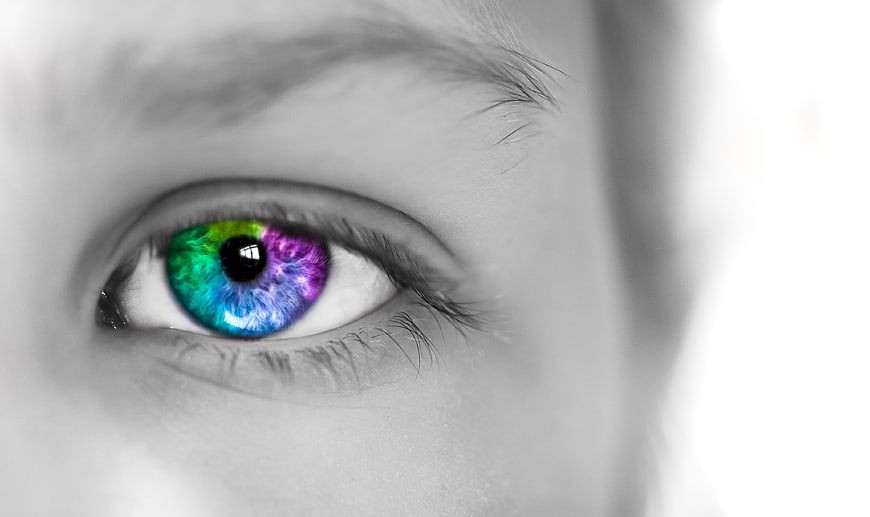 Close-up of eye with vibrant rainbow iris in black and white