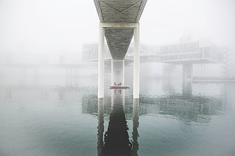 Foggy pier with boat and architectural reflection