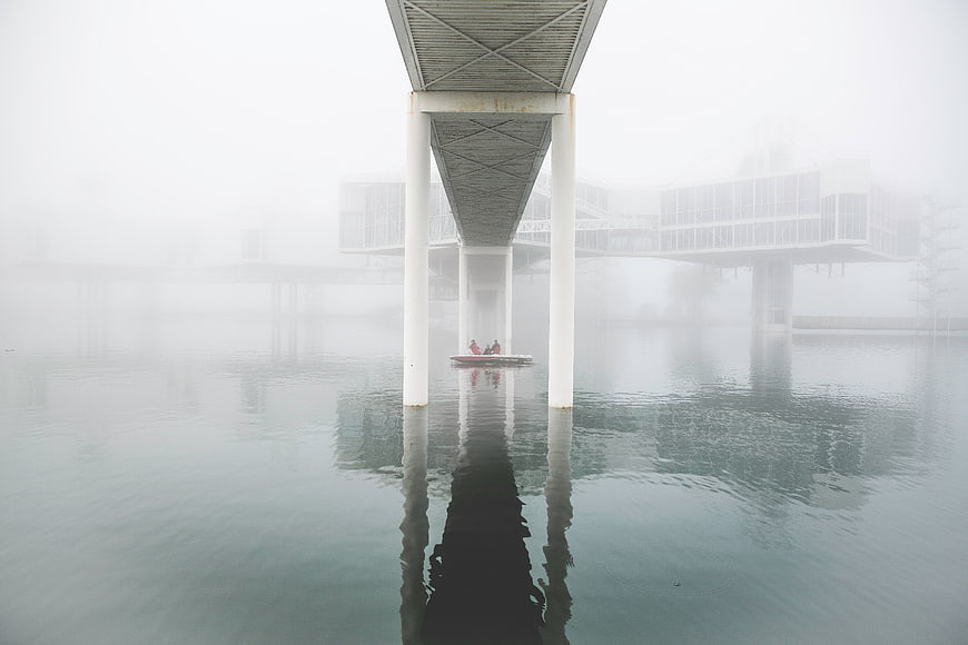 Foggy pier with boat and architectural reflection