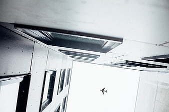 Low angle view of airplane flying over modern building