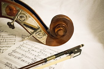 Close-up of Violin Scroll and Bow on Sheet Music