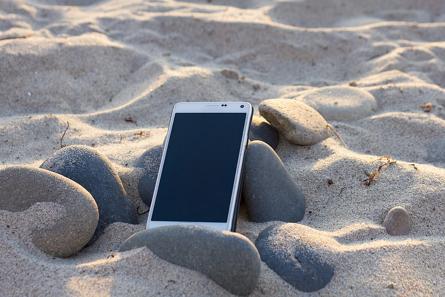 White Smartphone Mockup Leaning on Beach Stones