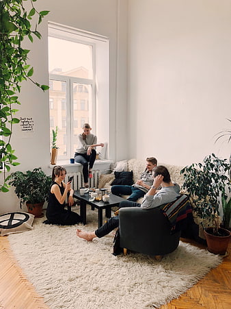 Friends relaxing in bright living room with plants