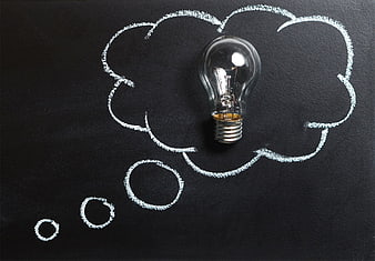 Light bulb inside chalk thought bubble on blackboard