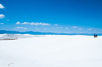 Vast White Sand Dunes Under Blue Sky with Distant Hikers