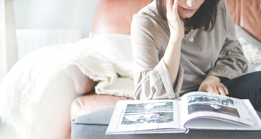 Woman Reading Magazine on Couch with Blanket