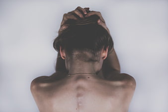Woman holding head in distress against white background