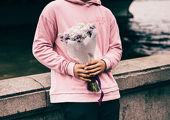 Person in Pink Hoodie Holding Bouquet of Baby's Breath