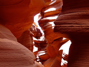 Sunlight streaming through red sandstone slot canyon walls