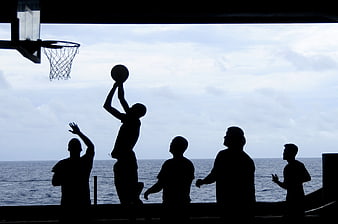 Silhouette of Men Playing Basketball by the Sea