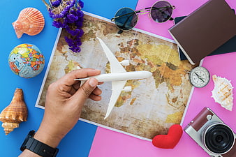 Travel planning flat lay with map, airplane, and accessories