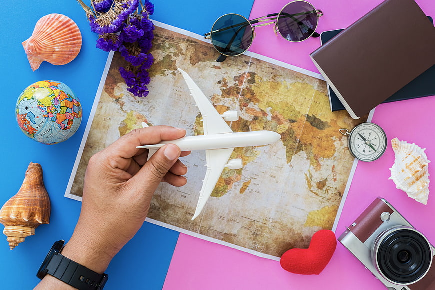 Travel planning flat lay with map, airplane, and accessories