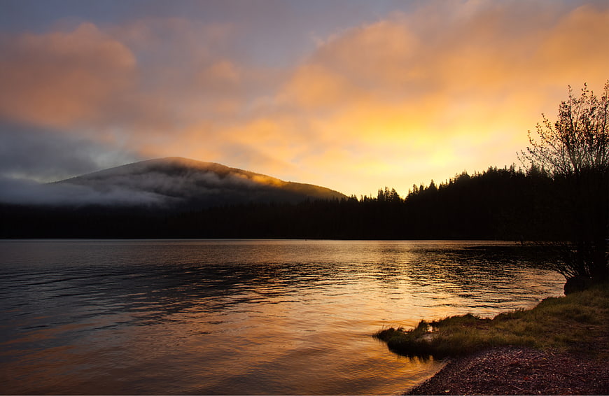 Serene Lake Sunrise with Misty Mountain and Forest Reflection