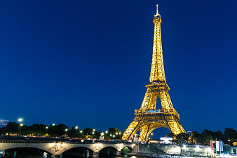 Eiffel Tower Illuminated at Night with Bridge in Paris