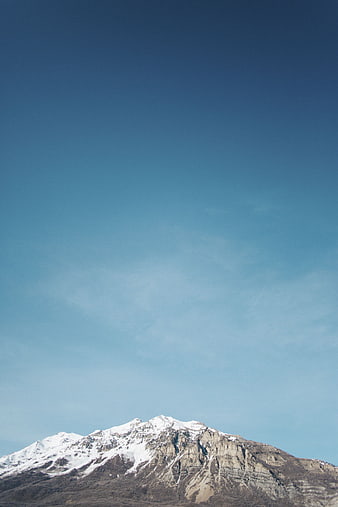 Snow-Capped Mountain Peak Against Clear Blue Sky