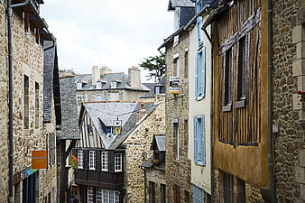 Narrow cobblestone street in historic French village with half-timbered houses