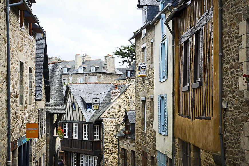 Narrow cobblestone street in historic French village with half-timbered houses