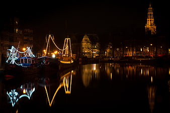 Night view of Groningen canal with illuminated boats and reflections