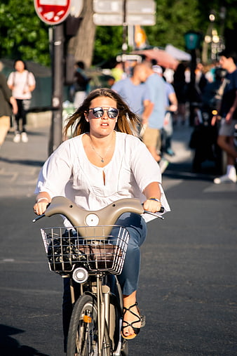 Young Woman Riding Bicycle in City Street