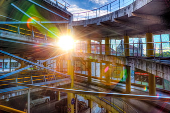 Sunlit multi-level concrete parking garage with lens flare