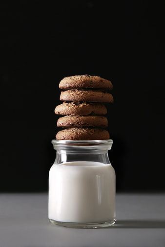 Stack of chocolate chip cookies on a glass of milk