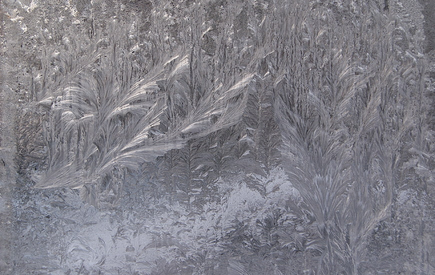 Intricate frost patterns on a frozen window pane