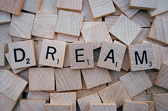 Wooden Scrabble Tiles Spelling Dream on Scattered Background