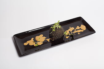 Gourmet food presentation on black rectangular plate