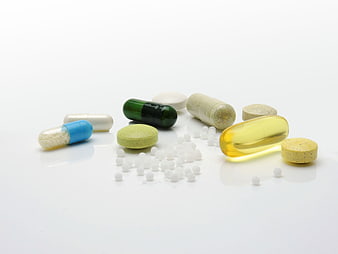 Assorted Vitamins, Supplements, and Medication Pills on White Background