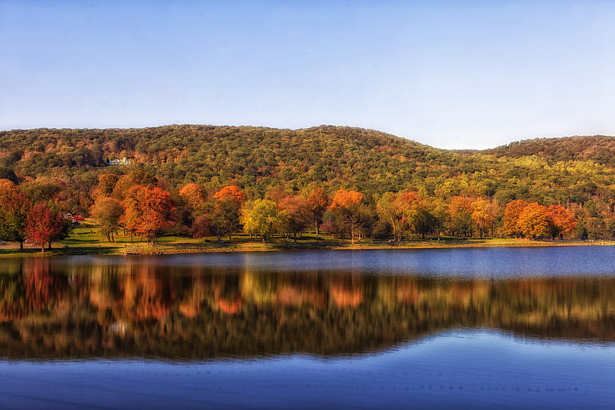 Scenic autumn landscape with colorful trees reflecting in a calm lake
