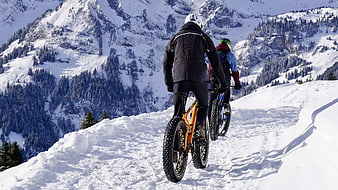 Two Cyclists Riding Fat Bikes on Snowy Mountain Trail