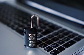 Open combination padlock on laptop keyboard symbolizing cybersecurity
