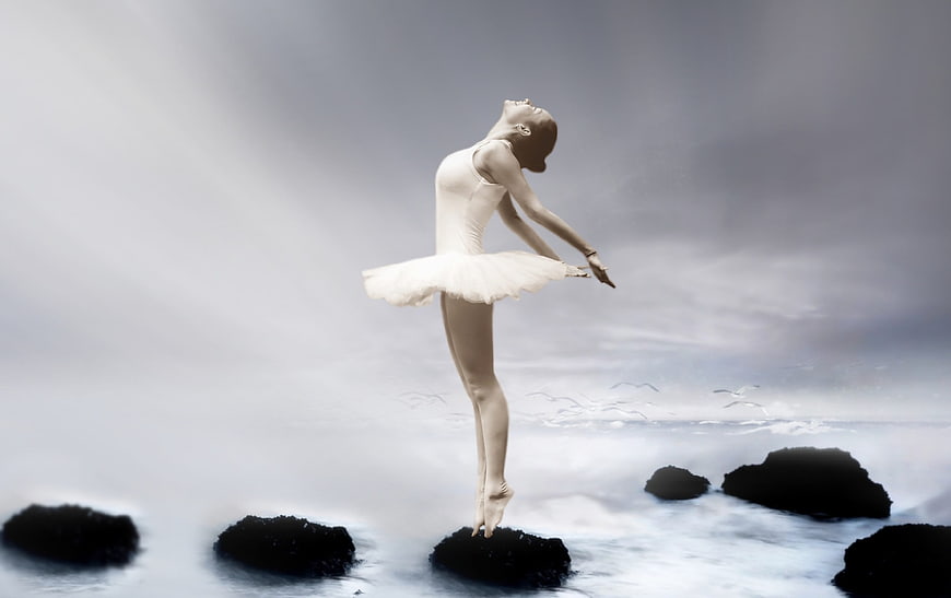 Ballerina dancing on rocks by the sea