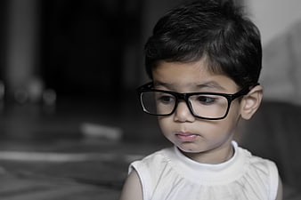 Portrait of a Young Child Wearing Black Glasses