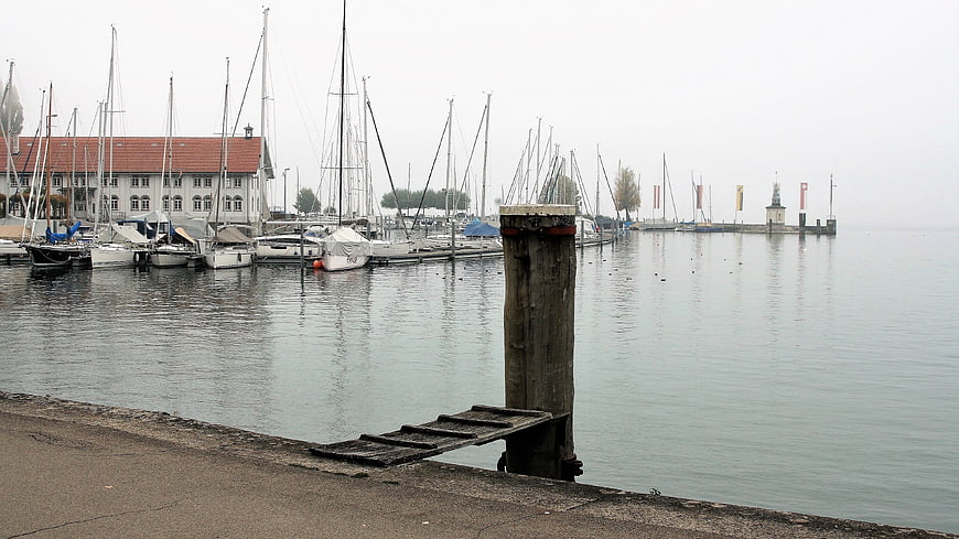 Sailboats docked in a misty harbor on a calm lake