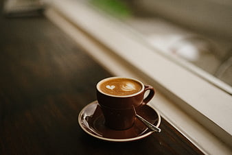 Latte Art Coffee Cup on Wooden Table by Window