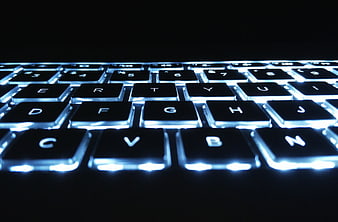 Close-up of a black backlit keyboard with blue LED lighting