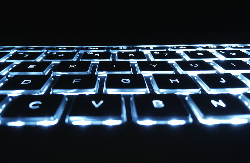 Close-up of a black backlit keyboard with blue LED lighting