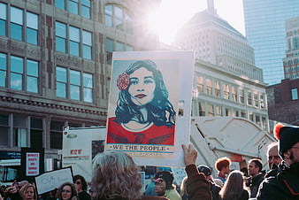 Protest sign with Frida Kahlo portrait at city rally