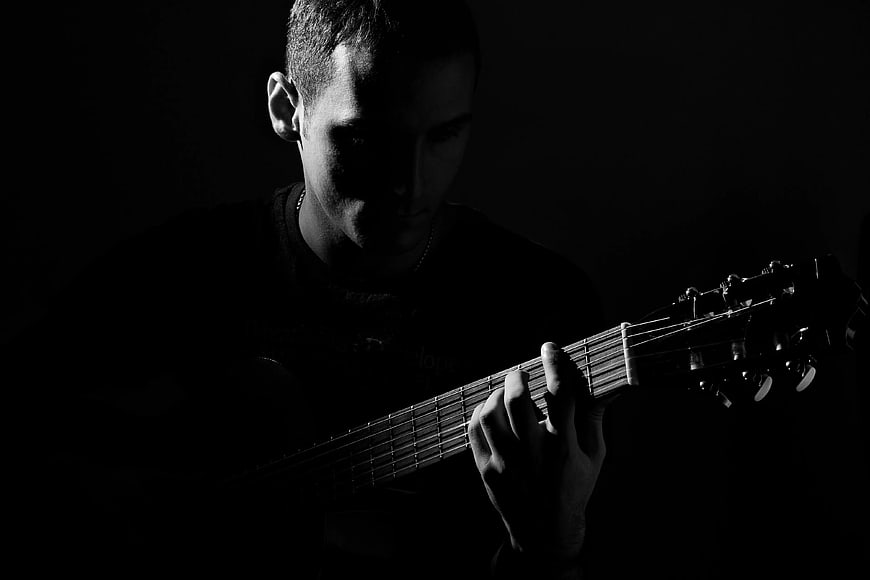Moody Black and White Man Playing Acoustic Guitar