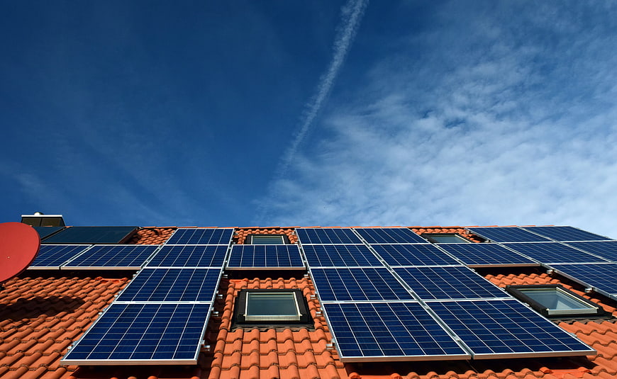 Solar Panels on Red Roof Against Blue Sky