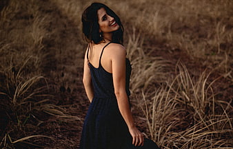 Smiling Woman in Polka Dot Dress in Dry Grass Field