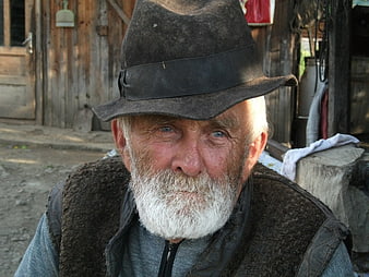 Portrait of Elderly Romanian Farmer in Rustic Village Setting